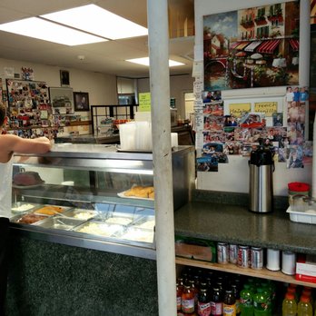 Sam's Deli - a woman standing in front of a deli counter - Delis Near Me - Glen Head, New York