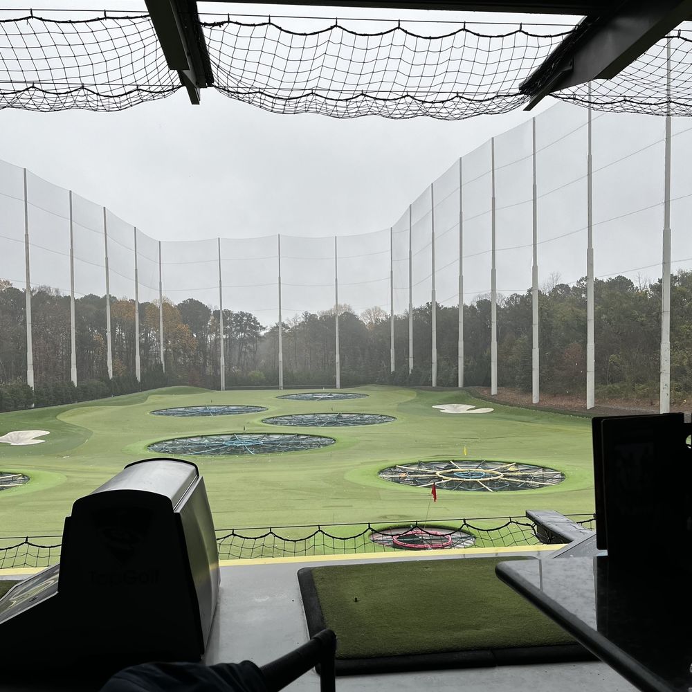 Topgolf - a view of a golf course through a window - Sports Bars Near Me - Alpharetta, Georgia Topgolf - a view of a golf course through a window - Sports Bars Near Me - Alpharetta, Georgia