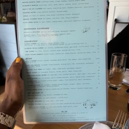 The menu from Bluebird Kitchen includes sections for starters, flatbreads, sandwiches, and main courses, with various options and prices.
