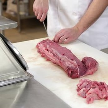 Columbia Meat Market - a chef chopping meat on a cutting board - Meat Shops Near Me - Staten Island, New York Columbia Meat Market - a chef chopping meat on a cutting board - Meat Shops Near Me - Staten Island, New York