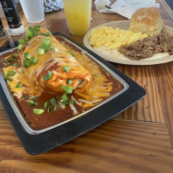 The Blue Hen Cafe - Breakfast burrito w/ sausage and red sauce, shredded pork with grits, homemade biscuit, scrambled eggs and a mimosa. - Southern Near Me - Saint Augustine, Florida