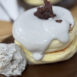 Black sesame whipped topping with black sesame ice cream and red bean on top of soufflet pancakes.