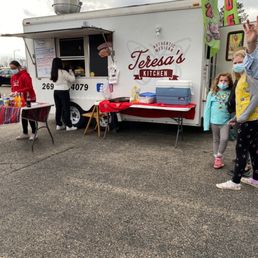 a food truck with people standing in front of it
