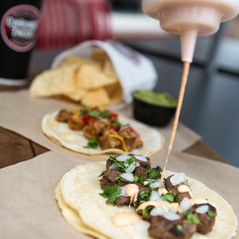 Chronic Tacos - a person putting sauce on a taco - Mexican Near Me - Riverside, California Chronic Tacos - a person putting sauce on a taco - Mexican Near Me - Riverside, California