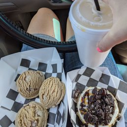 a person sitting in a car with a cup of coffee and cookies a person sitting in a car with a cup of coffee and cookies