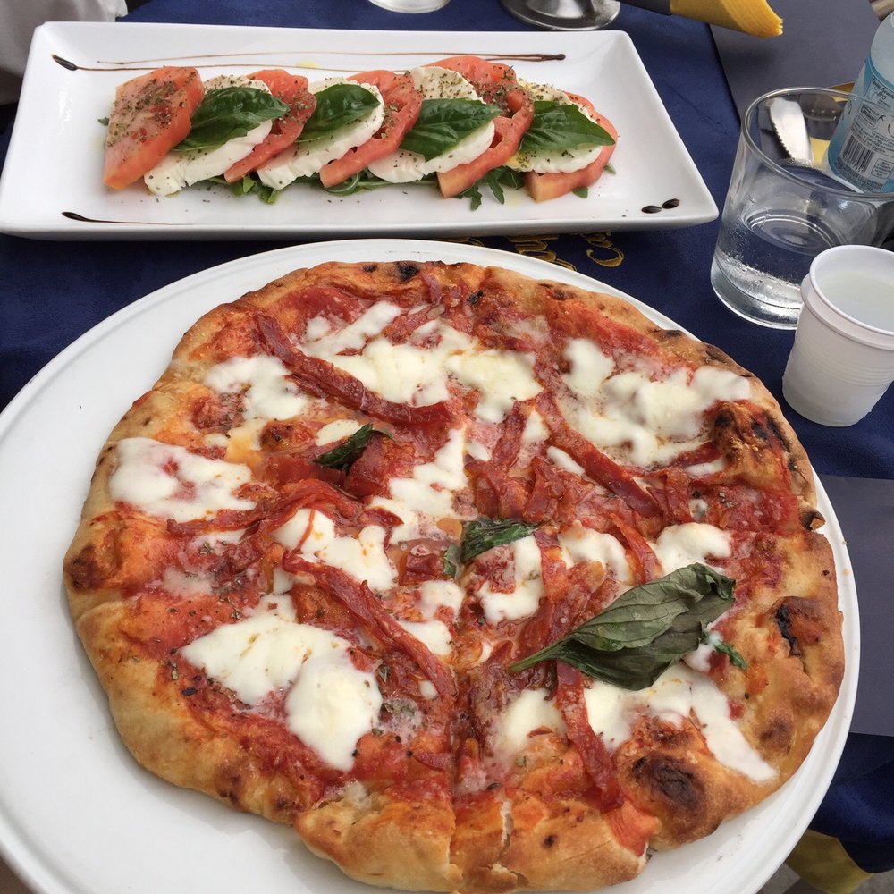 Spicy salami pizza and caprese salad. Spicy salami pizza and caprese salad.