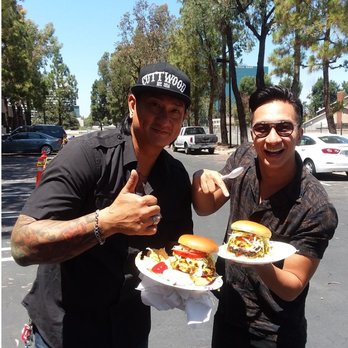 Beach Bus Bistro - two men holding plates of food - Food Trucks Near Me Beach Bus Bistro - two men holding plates of food - Food Trucks Near Me