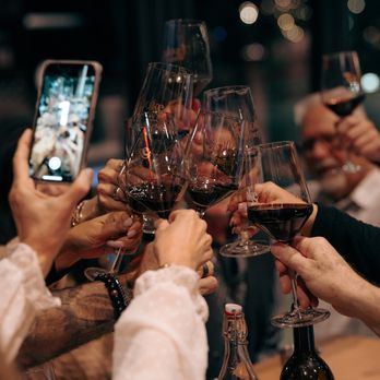 Evoke Winery - a group of people clinking wine glasses - Wine Tasting Room Near Me - Vancouver, Washington