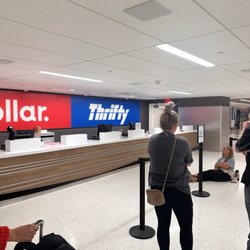 Dollar Car Rental - People waiting for the Dollar and Thrifty counter to open, 1 hour past the opening time of 6:00 am