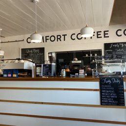 a coffee shop counter with chalkboard menus