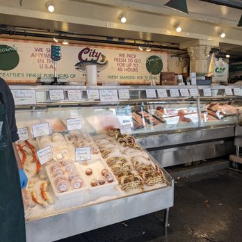 City Fish - a man standing in front of a display of seafood - Seafood Markets Near Me - Seattle, Washington