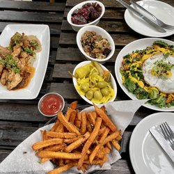 Levantine - Right- left: Quinoa Bowl $17, Sweet Potato Fries $7, Market Meze (Homemade pickles, Moroccan Eggplant, & beets) $22, & Chicken Pargiot $15