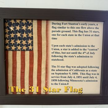 Fort Stanton Museum - The display includes an aged American flag with 31 stars, representing the Union, mounted inside a black frame. To the right of the flag, there is detailed text explaining the history of the flag, including its adoption and service dates. The title 'The 31 Star Flag' appears in large, yellow 3D letters at the bottom of the display. - Museums Near Me - Fort Stanton, New Mexico