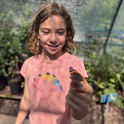 Helena enjoying with a butterfly landing on her