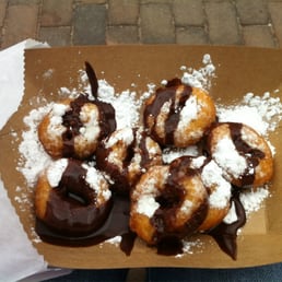 Mini donuts with powered sugar and chocolate sauce. Mini donuts with powered sugar and chocolate sauce.
