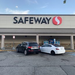 two cars parked in front of a safeway store