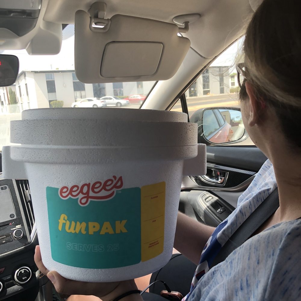 a woman holding a bucket of ice cream