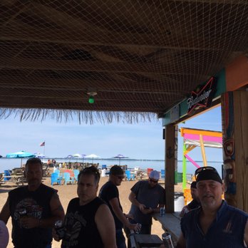 2 Cans Tiki Bar - a group of people on the beach - Tiki Bars Near Me - Vickery, Ohio