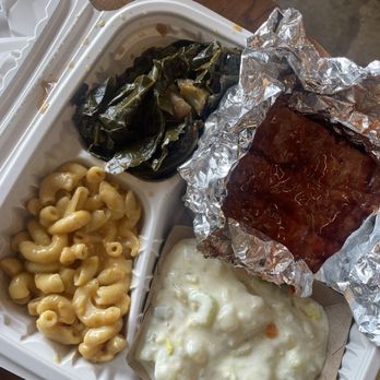 Herban Vegans - Jackfruit ribs, potato salad, Savory Mixed Greens, Miracle Mac TM - A vegan meal served in a compartmentalized container includes macaroni and cheese, collard greens, a barbecue jackfruit rib, and potato salad. - Vegan Near Me - Cincinnati, Ohio