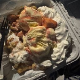 One tiny scoop of strawberries for this giant funnel cake One tiny scoop of strawberries for this giant funnel cake