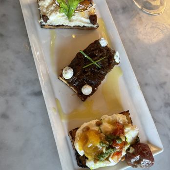 Fig & Olive - Riviera Crostini! We got (top to bottom) Lemon Ricotta, Confit Caramelized Onions w/ Goat Cheese, & Burrata w/ Cherry Tomatoes *chefs kiss* - French Near Me - Houston, Texas