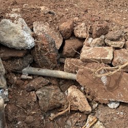Precise Masonry Contractors - Buried rocks, concrete, asphalt and metal fence pipe.