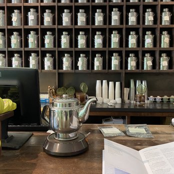 Gong Fu Tea - a teapot and a book on a table - Coffee & Tea Near Me - Des Moines, Iowa