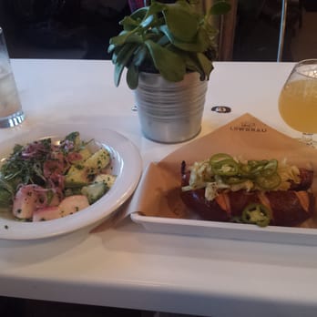 LowBrau - Cucumber salad and a lamb sausage on a pretzel roll. - German Near Me - Sacramento, California LowBrau - Cucumber salad and a lamb sausage on a pretzel roll. - German Near Me - Sacramento, California