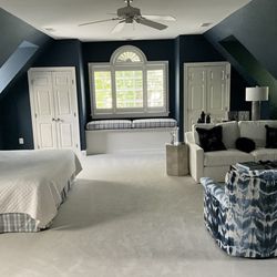 Classic Interiors - Dramatic dark blue paint dramatizes the white woodwork in this guest  bedroom over a garage.
