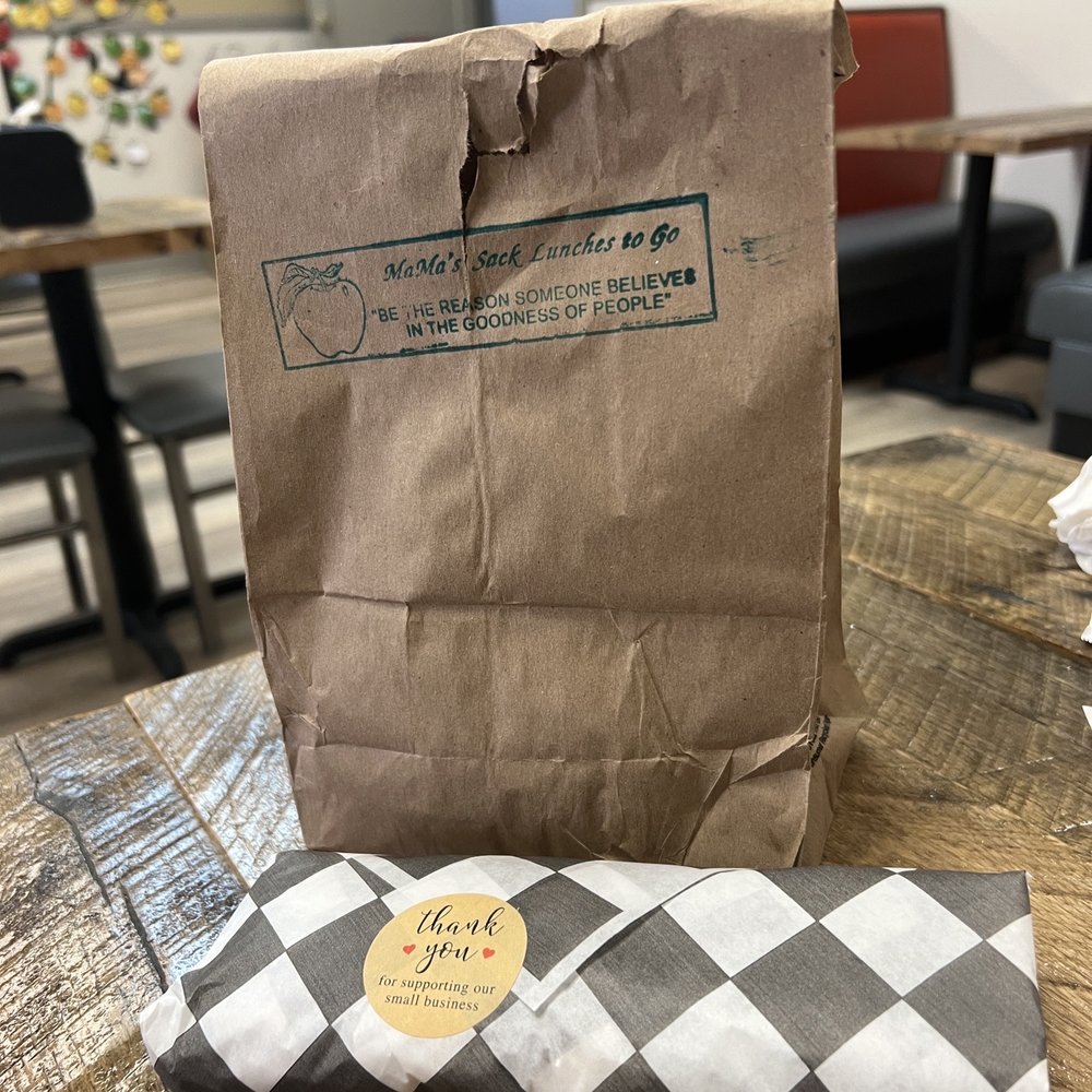 Mama's Sack Lunches - a brown paper bag and a checkered paper roll - Delis Near Me - Montgomery, Alabama