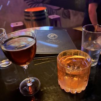 La Viuda Negra - two glasses of wine and a book on a table - Bars Near Me - Dallas, Texas La Viuda Negra - two glasses of wine and a book on a table - Bars Near Me - Dallas, Texas
