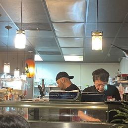The owner hands on behind the sushi bar. Doing what he loves.