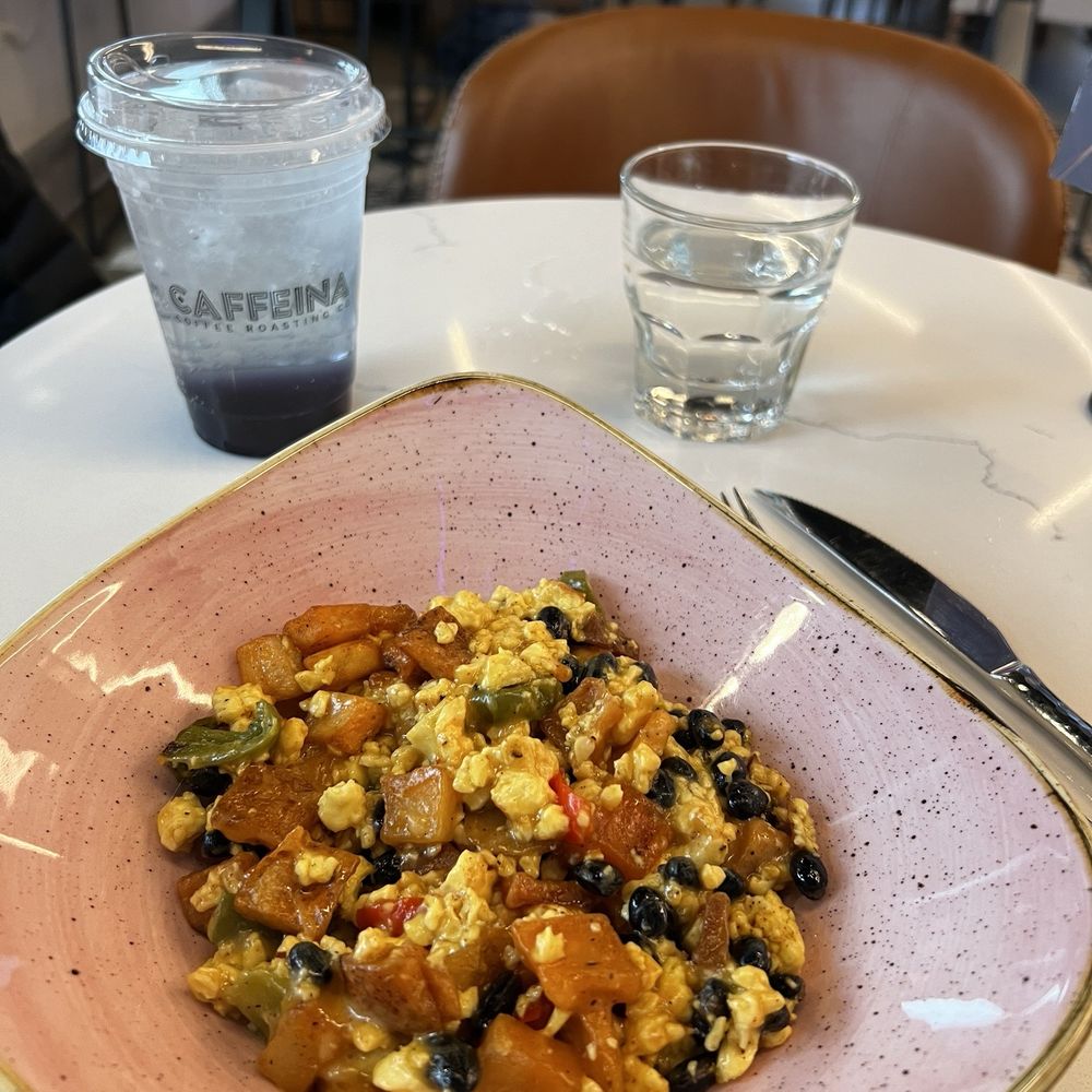 Breakfast bowl with black beans and a lotus energy drink.