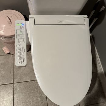The Mosaic Workshop - The bathroom bidet - A white toilet with an integrated bidet and electronic control panel is installed in a bathroom with tiled flooring. - Art Classes Near Me - Austin, Texas