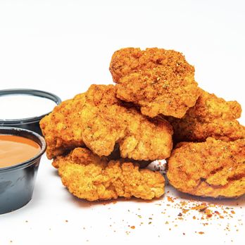 Tyga Bites - a pile of fried chicken nuggies with dipping sauce - Comfort Food Near Me Tyga Bites - a pile of fried chicken nuggies with dipping sauce - Comfort Food Near Me