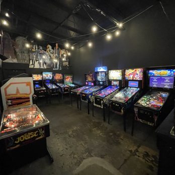 Recbar - a row of pinball machines in a dark room - Bars Near Me - Louisville, Kentucky