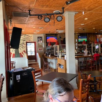 Proud Larry's - a woman sitting at a table in a restaurant - Sandwiches Near Me - Oxford, Mississippi