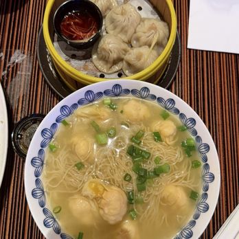 Noodles - (Top) Xiao Long Bao and (Bottom) BBQ Pork Noodle Soup - A bowl of noodle soup with shrimp dumplings and chopped green onions, alongside a bamboo steamer with steamed dumplings and dipping sauce. - Chinese Near Me - Pala, California