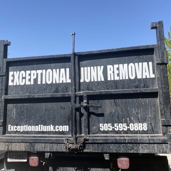 Exceptional Junk Removal - Highly recommend! - A black truck used for junk removal services, featuring the company name 'Exceptional Junk Removal' and the website 'ExceptionalJunk.com' along with a phone number. The truck is parked outdoors, with trees and other vehicles visible in the background under a clear blue sky. - Junk Removal & Hauling Near Me