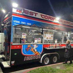 a woman standing in front of a food truck