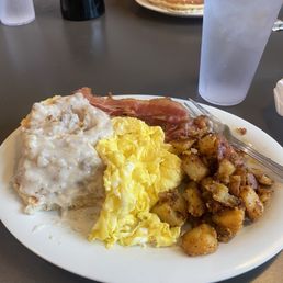 Biscuit with sausage gravy, scrambled eggs, 2 strips of bacon, red potatoes.