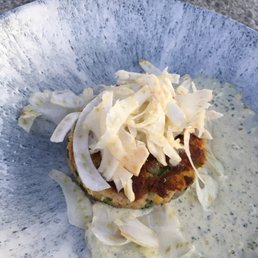 Crab cake appetizer with slaw and remoulade.