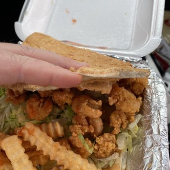 Nawlins Style Po’Boys - a hand holding a sandwich - Food Trucks Near Me Nawlins Style Po’Boys - a hand holding a sandwich - Food Trucks Near Me