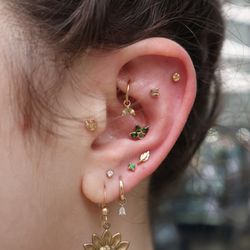 Deep Roots Tattoo & Body Piercing - Ear curation. Piercings styled with jewelry from Buddha and BVLA in solid yellow gold.