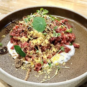The Nash - a bowl of food on a wooden table - Bars Near Me - Calgary, Alberta