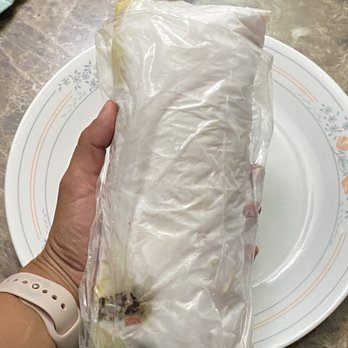 PrimeTime Donair - a person holding a sandwich wrapped in plastic - Donairs Near Me - Edmonton, Alberta PrimeTime Donair - a person holding a sandwich wrapped in plastic - Donairs Near Me - Edmonton, Alberta