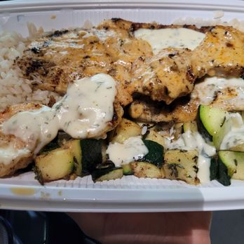 California Fish Grill - Barramundi with half Cajun and half garlic butter, we got it served with a bed of white rice and rosemary zucchini . - Seafood Near Me - Costa Mesa, California