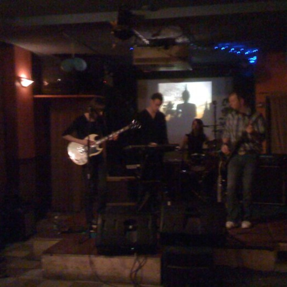 The Smiling Buddha - a group of people playing music in a dimly lit room - Music Venues Near Me - Toronto, Ontario The Smiling Buddha - a group of people playing music in a dimly lit room - Music Venues Near Me - Toronto, Ontario