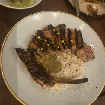 Joyce - Tomahawk pork chop with grits & green tomato chow chow. 10/10 - Southern Near Me - Los Angeles, California