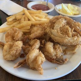 Fried shrimp dinner, onion rings, French fries and cocktail sauce. Fried shrimp dinner, onion rings, French fries and cocktail sauce.